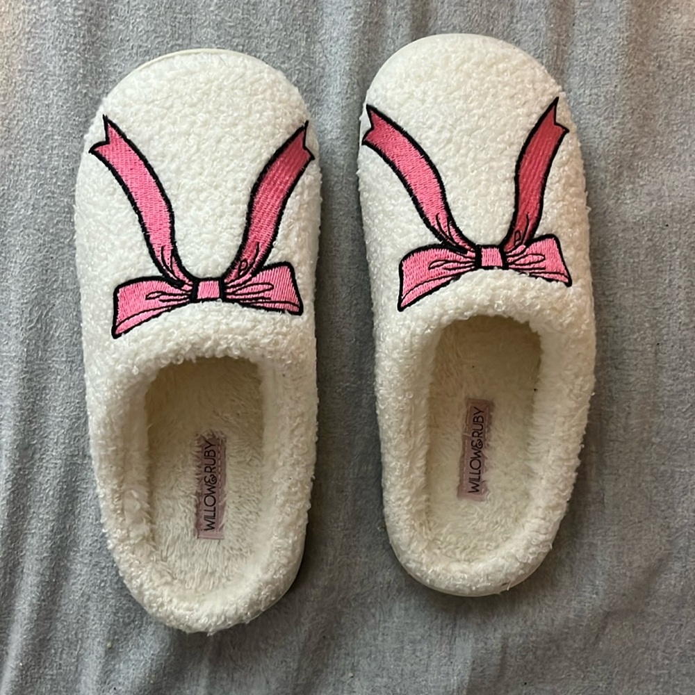 White fluffy slippers with pink bows on them 
Never worn size 6